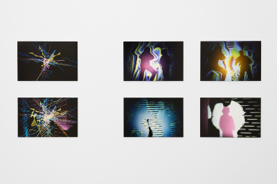 Sechs digital anmutende Kunstwerke hängen in zwei Reihen an einer weißen Galeriewand. Die Bilder zeigen abstrakte Linienkompositionen sowie verfremdete Silhouetten von Menschen in leuchtenden Neonfarben und unscharfen Konturen auf dunklem Hintergrund.