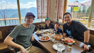 Zwei Männer mit zwei Kids beim Essen im Gasthof zum Bäreneck nahe der Mittelstation der Gemeindealpe.