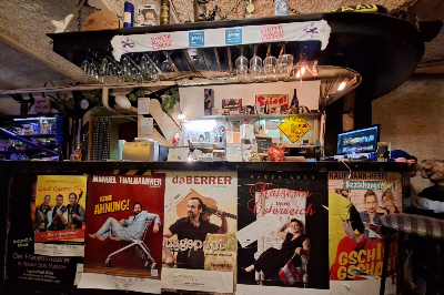 Getränke-Bar mit Plakaten in der Tschoscherl Bar