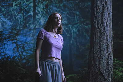 Hannah Einbinder als Kris rennt gehetzt durch den Wald