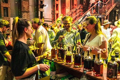 Man und Frau stehen vor einer Bar mit großer Rumauswahl beim Vienna Rumfestival.
