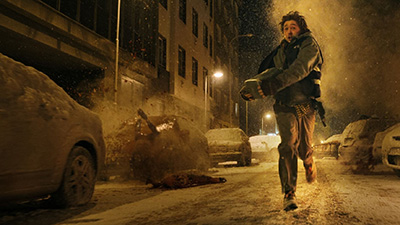 Austin Abrams als Bryan läuft mit Waffe durch die Straßen von Raccoon City