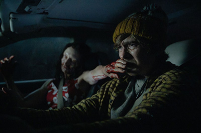 Austin Abrams als Bryan fährt mit einer Infizierten im Auto