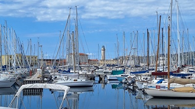 Ein Leuchtturm am Hafen von Triest mit blauem Himmel.