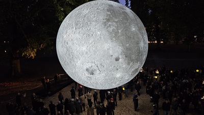 7 Meter große Mondinstallation hängt über den Besucher:innen von Klanglicht im Park im Schwarzenberggarten